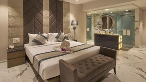 A modern bedroom with a bed, bedside table, lamp, and a ceiling fan. - Regenta Central Imperial Candolim (Candolim)