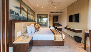 A modern hotel room with a large bed, a desk, a TV, and a bathroom visible through an open door. - Regenta Central Imperial Candolim (Candolim)