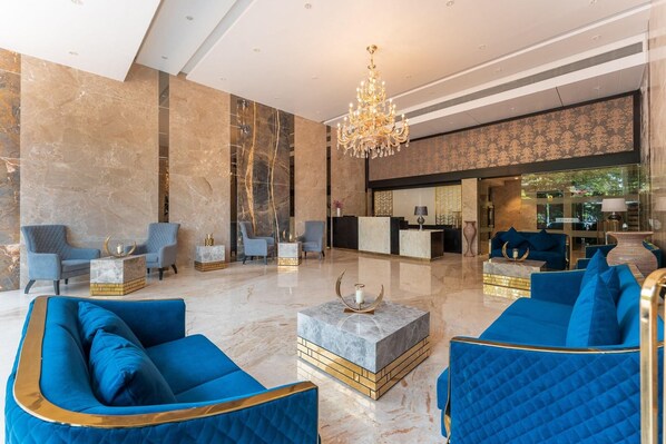 A spacious lobby with marble flooring, a grand chandelier, and blue upholstered seating. - Regenta Central Imperial Candolim (Candolim)