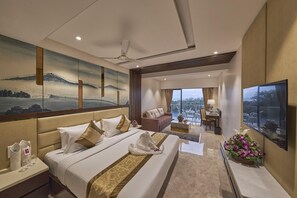A hotel room with a bed, a sofa, a desk, and a TV. - Regenta Central Imperial Candolim (Candolim)