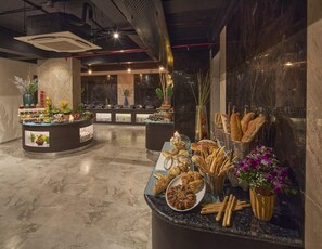 A buffet area with various food items and a marble floor. - Regenta Central Imperial Candolim (Candolim)