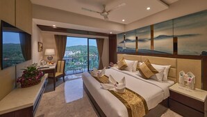 A hotel room with a large bed, a desk, a chair, a TV, and a balcony with a view. - Regenta Central Imperial Candolim (Candolim)