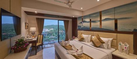 A hotel room with a large bed, a desk, a chair, a TV, and a balcony with a view.