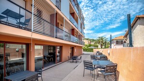 A multi-story building with outdoor seating and a balcony.