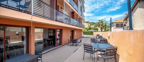 A multi-story building with outdoor seating and a balcony.