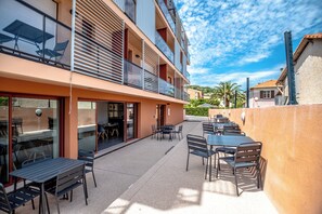 A multi-story building with outdoor seating and a balcony. - Hotel Le Virevent (Saint-Raphael)