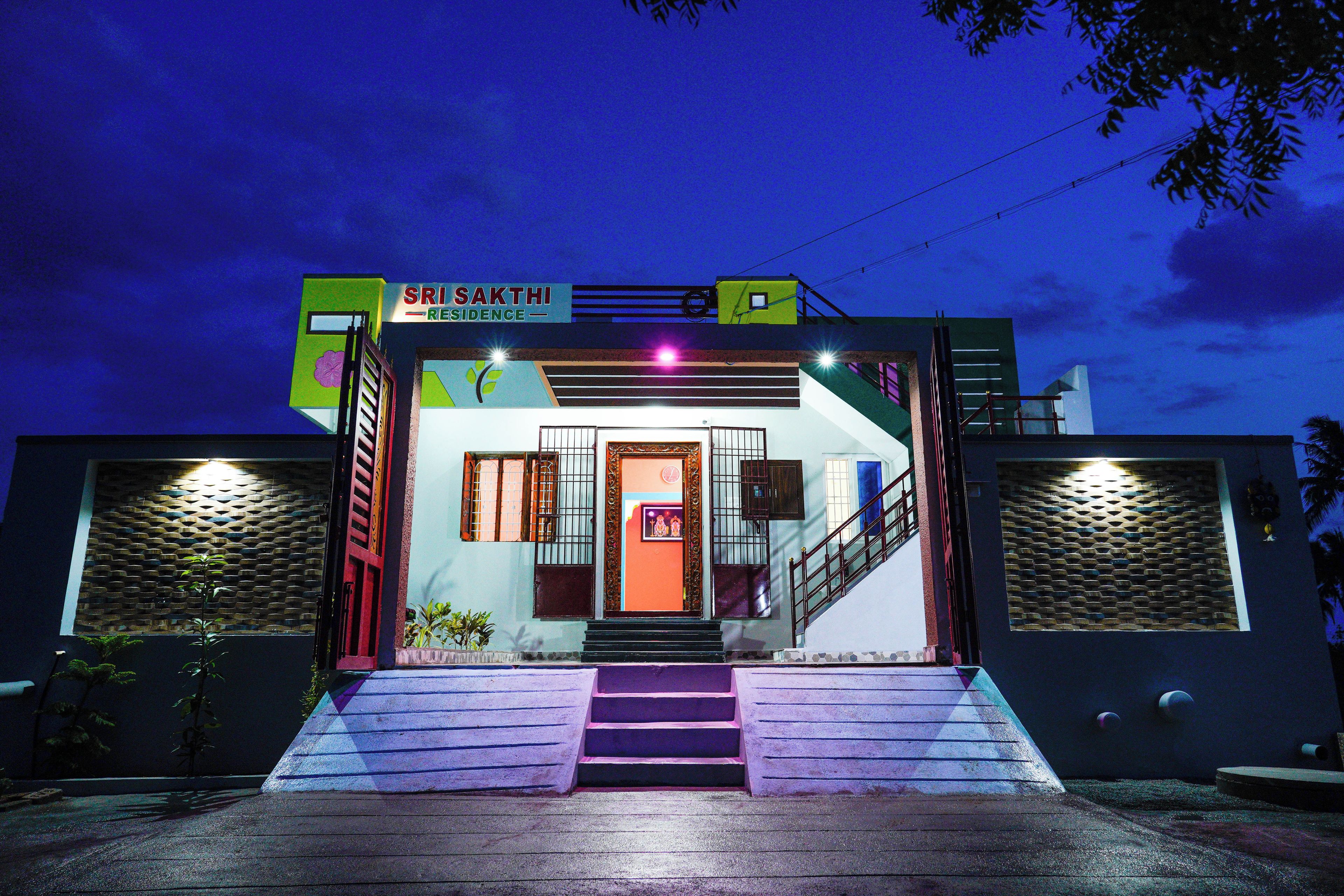 A building with a sign reading "SRI SAKTHI RESIDENCE" and a staircase leading to the entrance.