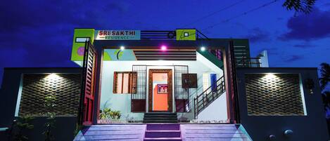 A building with a sign reading "SRI SAKTHI RESIDENCE" and a staircase leading to the entrance.