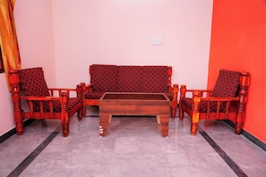A living room with a sofa set, two armchairs, and a coffee table. - Sri Sakthi Residence (Tiruvannamalai)