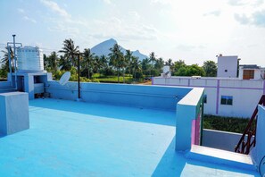 A rooftop with a blue floor, a satellite dish, and a water tank. - Sri Sakthi Residence (Tiruvannamalai)