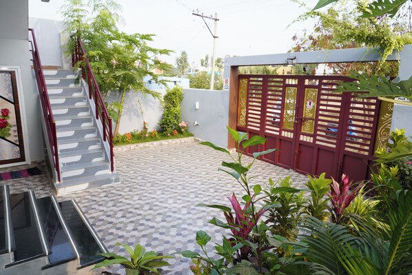 Ein Wohngebiet mit einer Treppe, die zu einer Tür führt, einer gefliesten Terrasse und einem verschlossenen Eingang.
