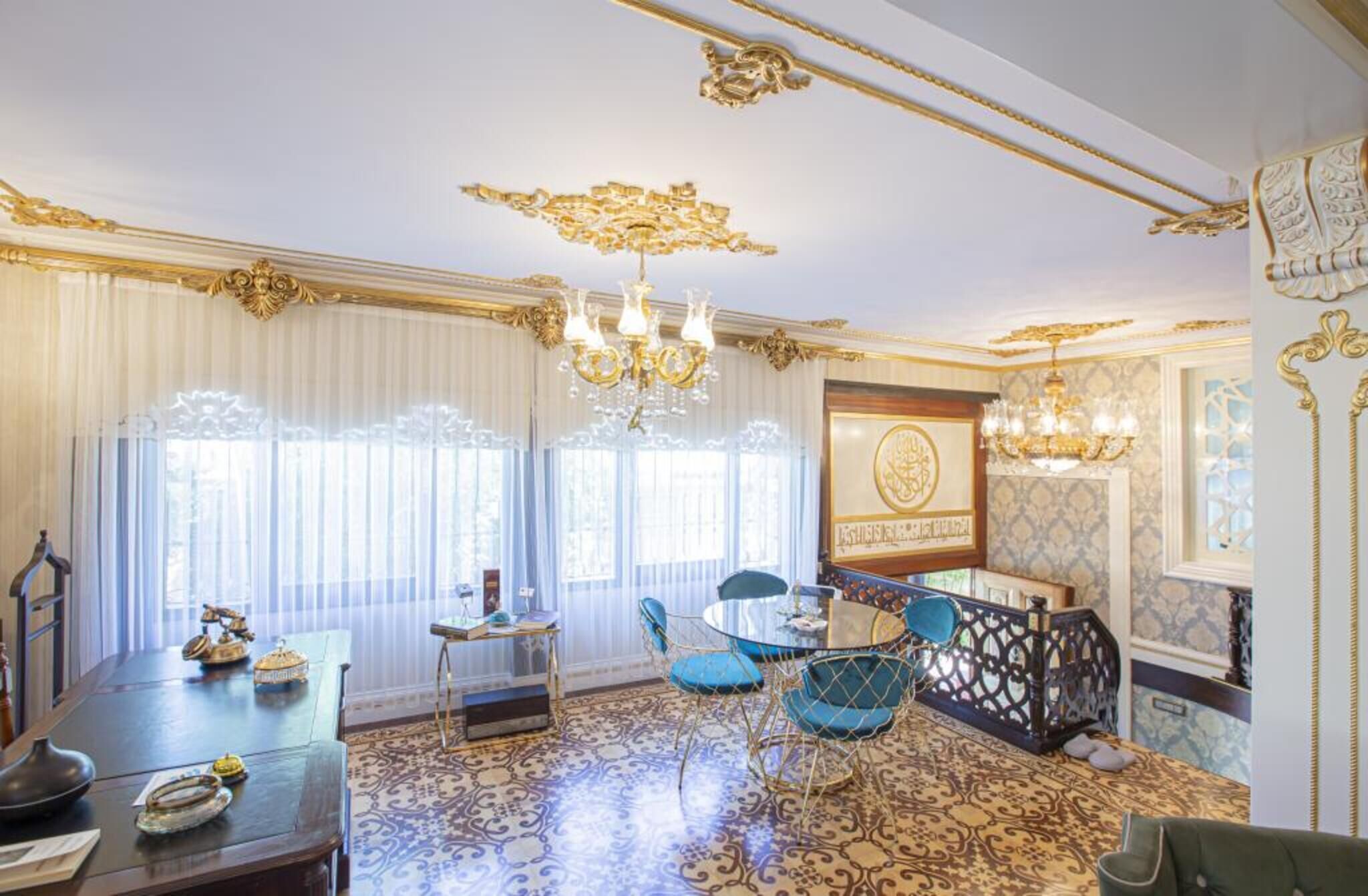 A room with a patterned floor, a chandelier, a table with chairs, and a decorative wall.