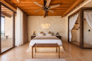 A bedroom with a large bed, wooden ceiling fan, and a view of the sea through a glass door. - Awa Holbox Hotel Boutique - Beach Front (Isla Holbox)