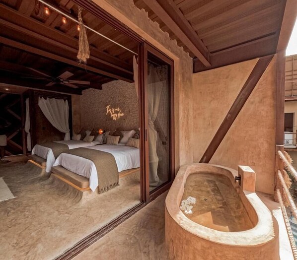 A bedroom with a large bed, a wooden ceiling, and a bathtub. - Awa Holbox Hotel Boutique - Beach Front (Isla Holbox)
