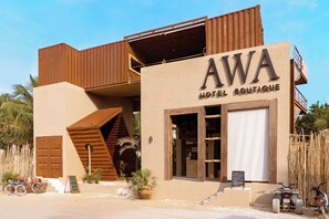 A hotel named AWA with a modern design, featuring a prominent signboard, a staircase, and a vehicle parked outside. - Awa Holbox Hotel Boutique - Beach Front (Isla Holbox)