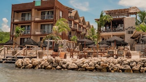 A resort with multiple buildings, outdoor seating areas, and a rocky shoreline. - Awa Holbox Hotel Boutique - Beach Front (Isla Holbox)