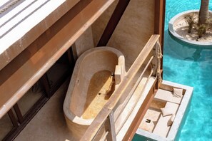 A wooden bathtub in a poolside setting with a view of the pool and a palm tree. - Awa Holbox Hotel Boutique - Beach Front (Isla Holbox)