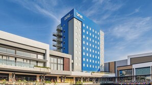 A modern hotel with a prominent blue and white facade, multiple floors, and a flat roof. - One Mazatlán (Mazatlan)