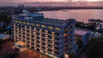 Un hotel de varios pisos con balcones, piscina y vista al agua.