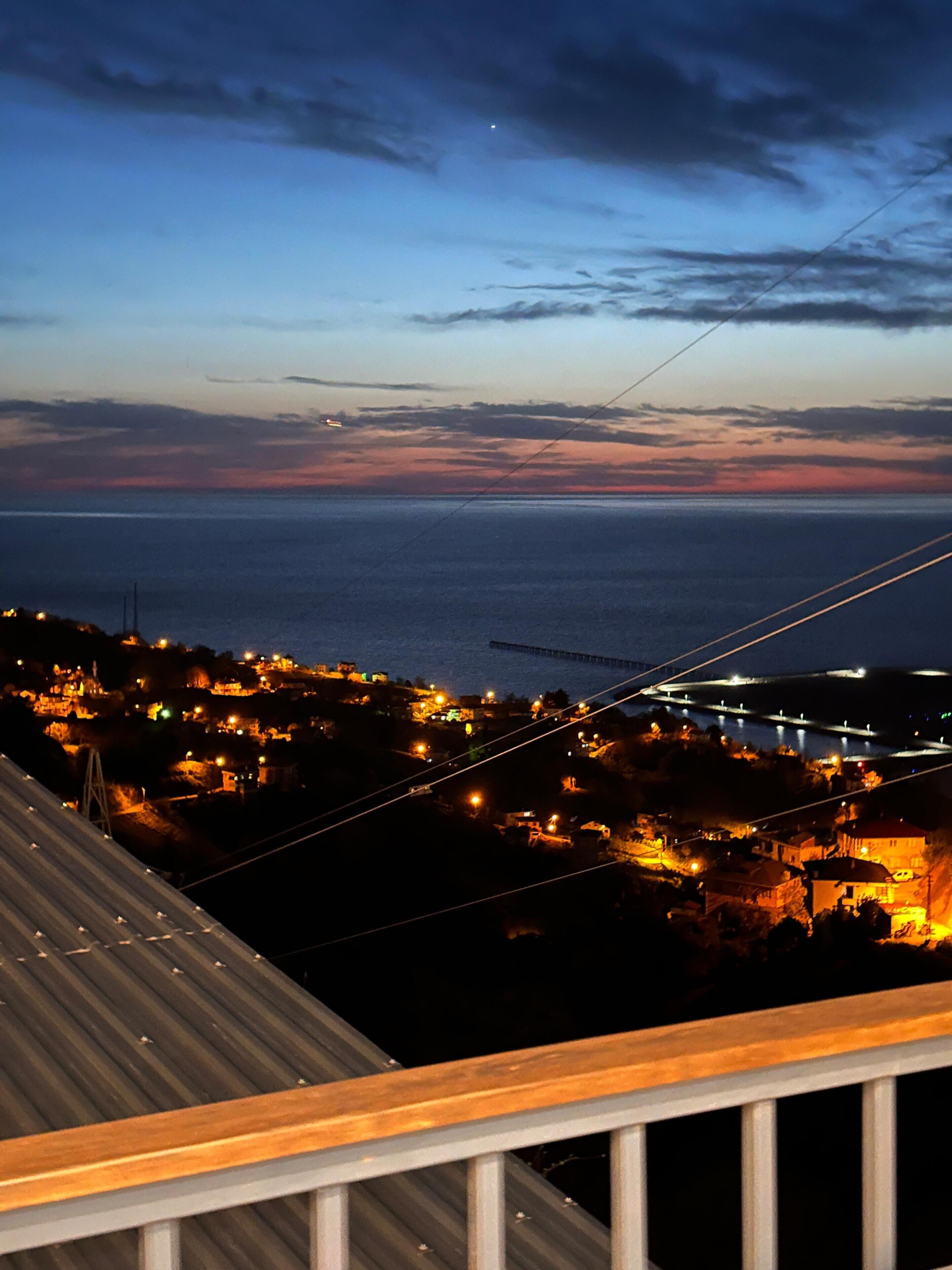 Un pueblo costero al atardecer con vista al mar y un puente.