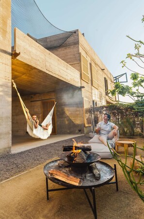 A hammock, a fire pit, and a person sitting outside a building. - Paradero Todos Santos (Todos Santos)