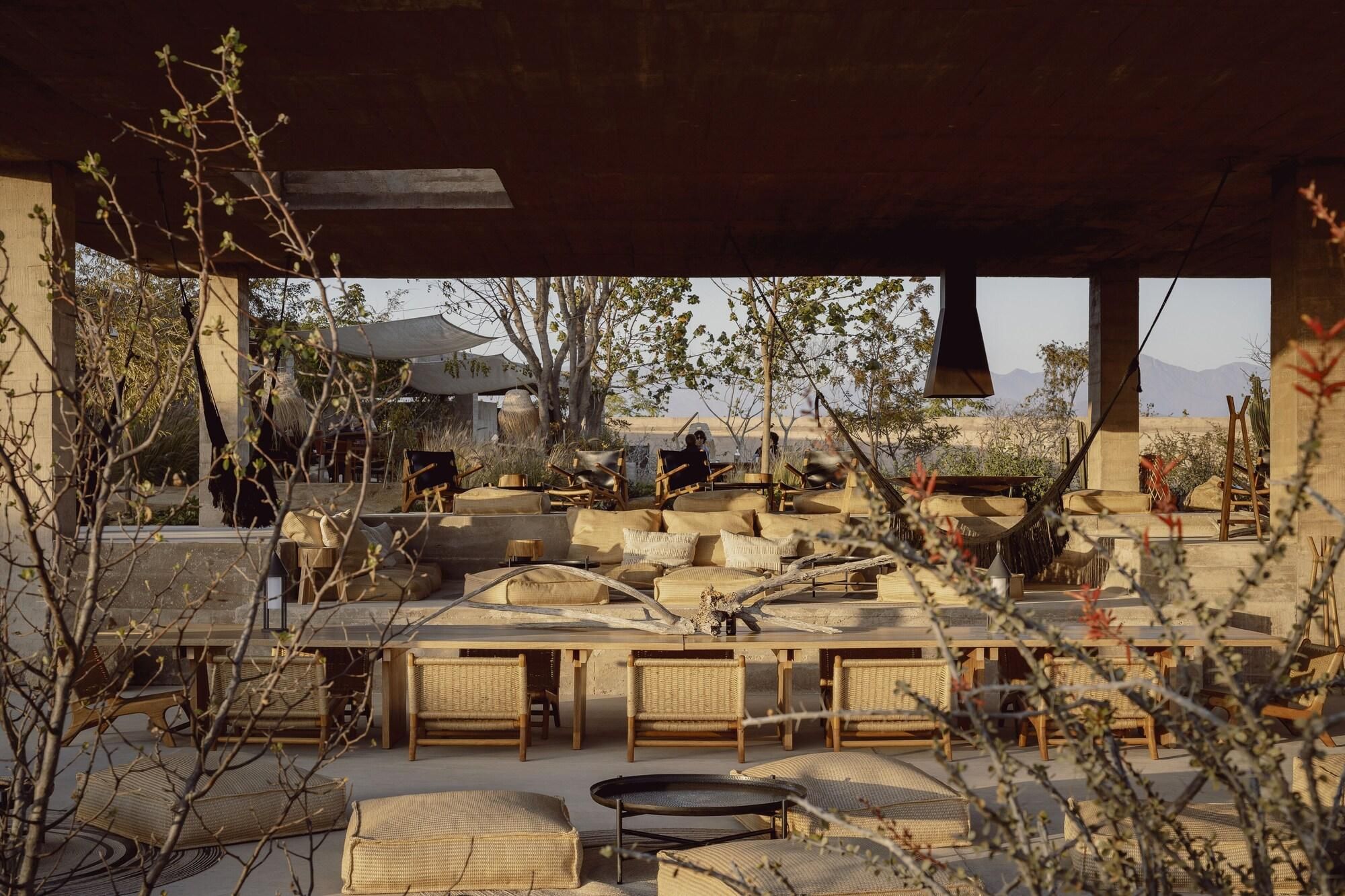 An outdoor seating area with wicker furniture and a view of the desert landscape.