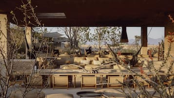 An outdoor seating area with wicker furniture and a view of the desert landscape.