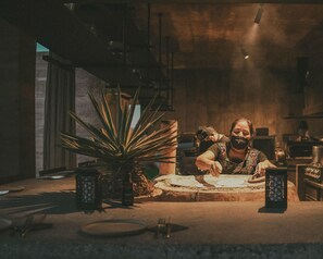 Iemand werkt aan een tafel, met een plant, een kaars en een laptop.