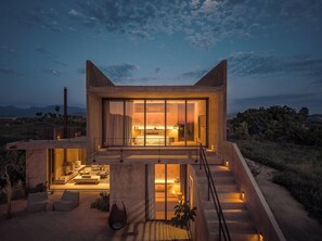 Een modern huis met een groot raam, een wenteltrap en een patio.