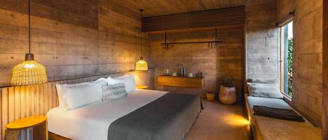A bedroom with a bed, bedside tables, a window, and a wooden ceiling.