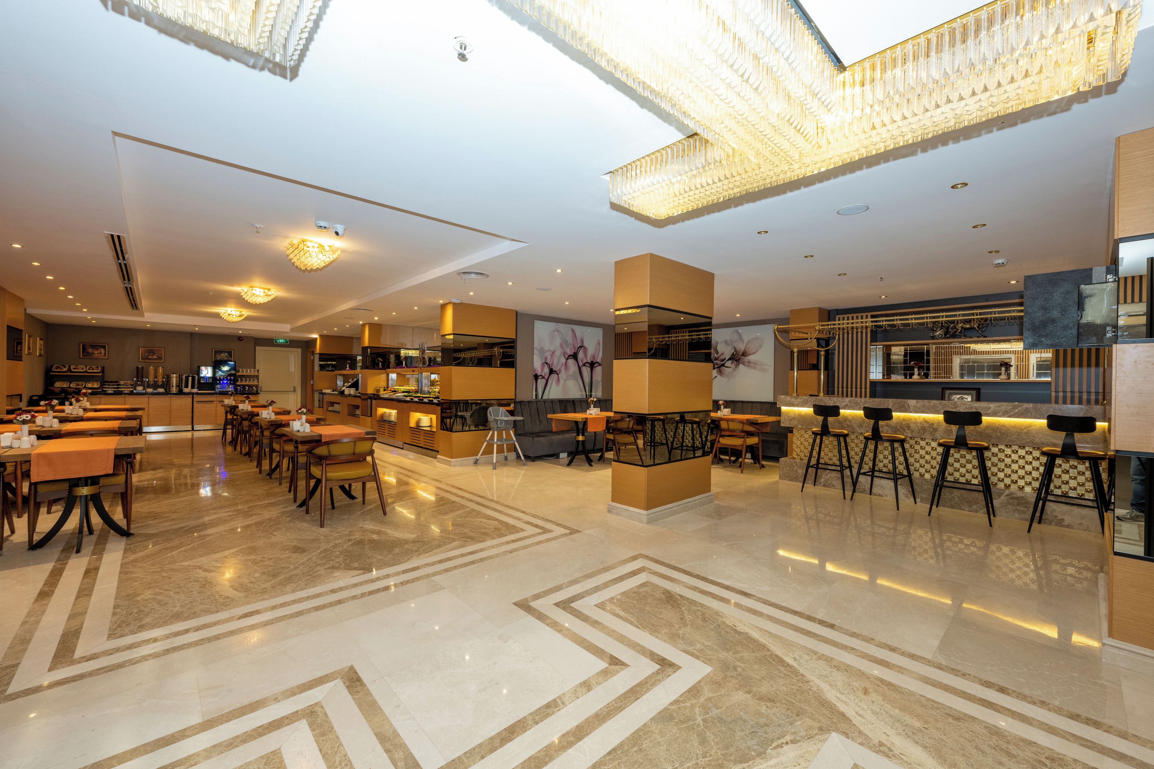 Un rebedor d'hotel modern amb una zona de bar, zones d'estar i un sòl net i polit.