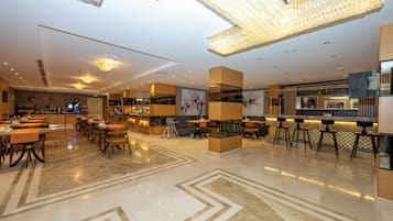 Un rebedor d'hotel modern amb una zona de bar, zones d'estar i un sòl net i polit.