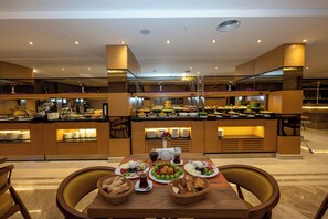 Ein reichhaltiges Buffet mit verschiedenen Speisen sowie ein Tisch mit Tellern und Körben.