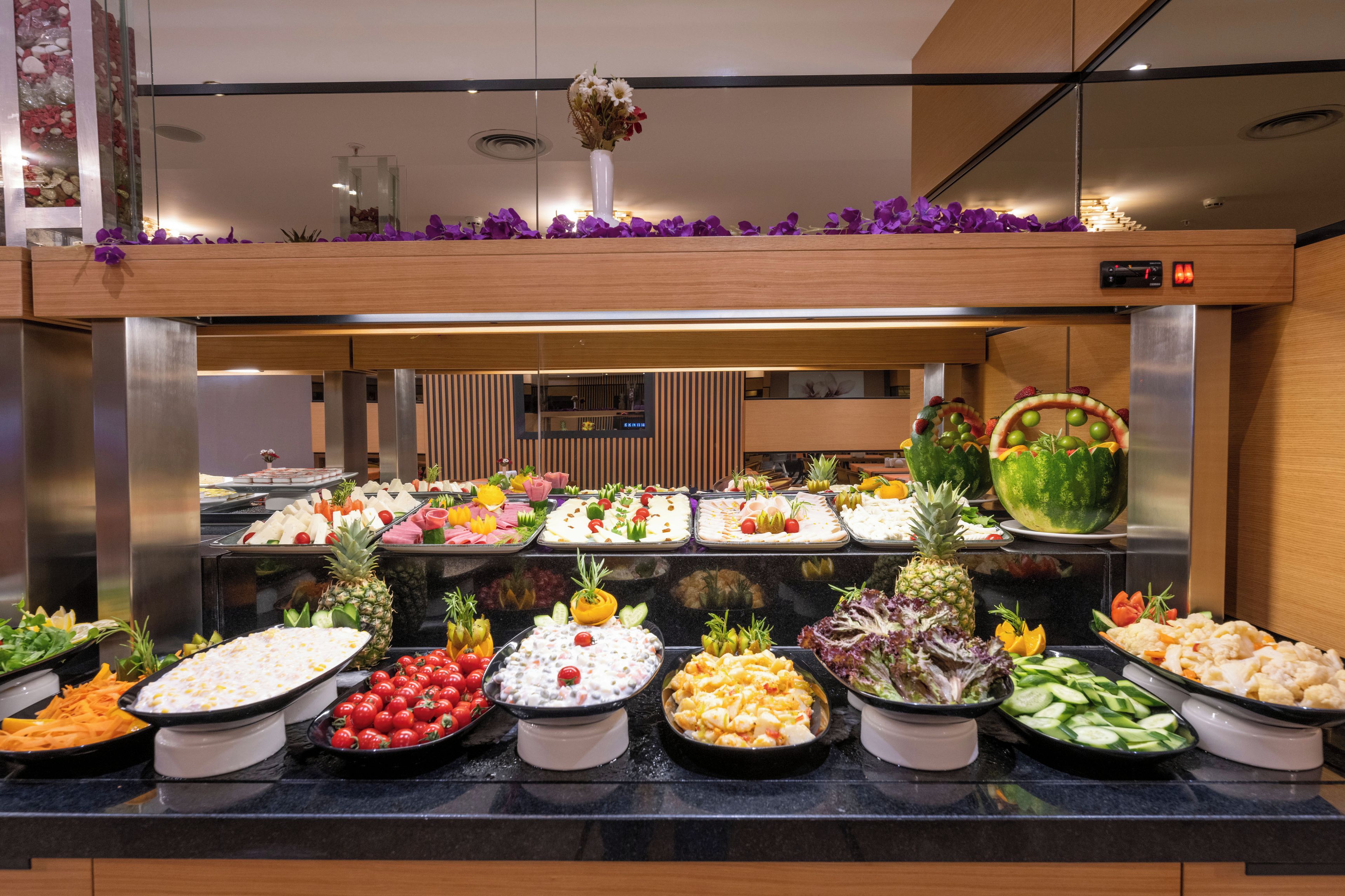 A buffet with various food items and a decorative vase on the counter.