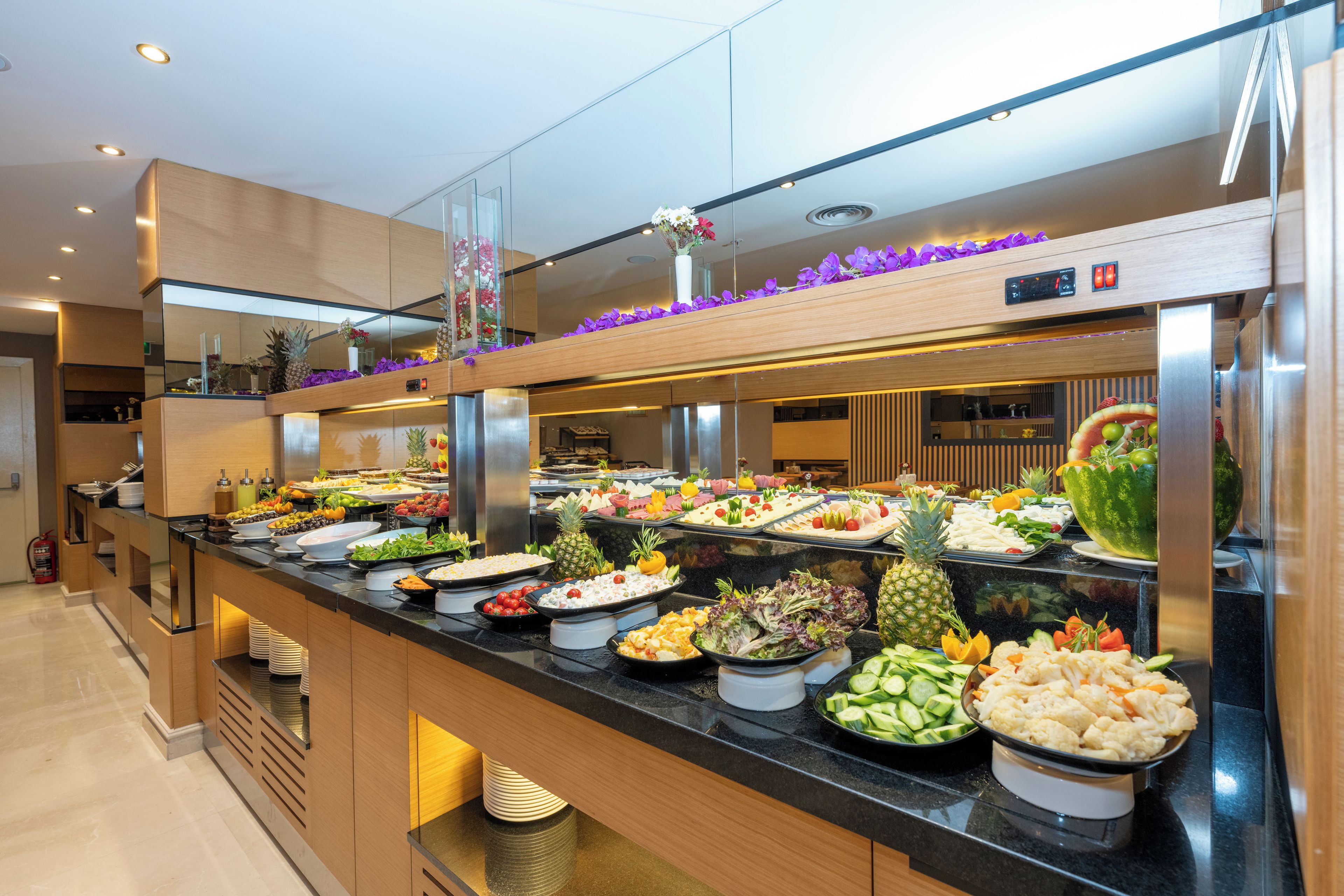 Ein reichhaltiges Buffet mit verschiedenen Speisen und einer dekorativen Blumenanordnung.