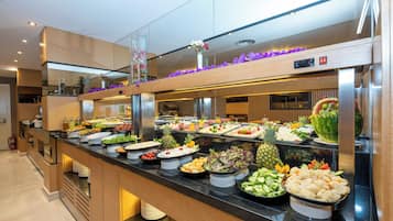 Ein reichhaltiges Buffet mit verschiedenen Speisen und einer dekorativen Blumenanordnung.