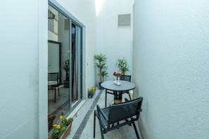 A small patio with a round table, two chairs, and potted plants. - Freya Hotel (Istanbul)