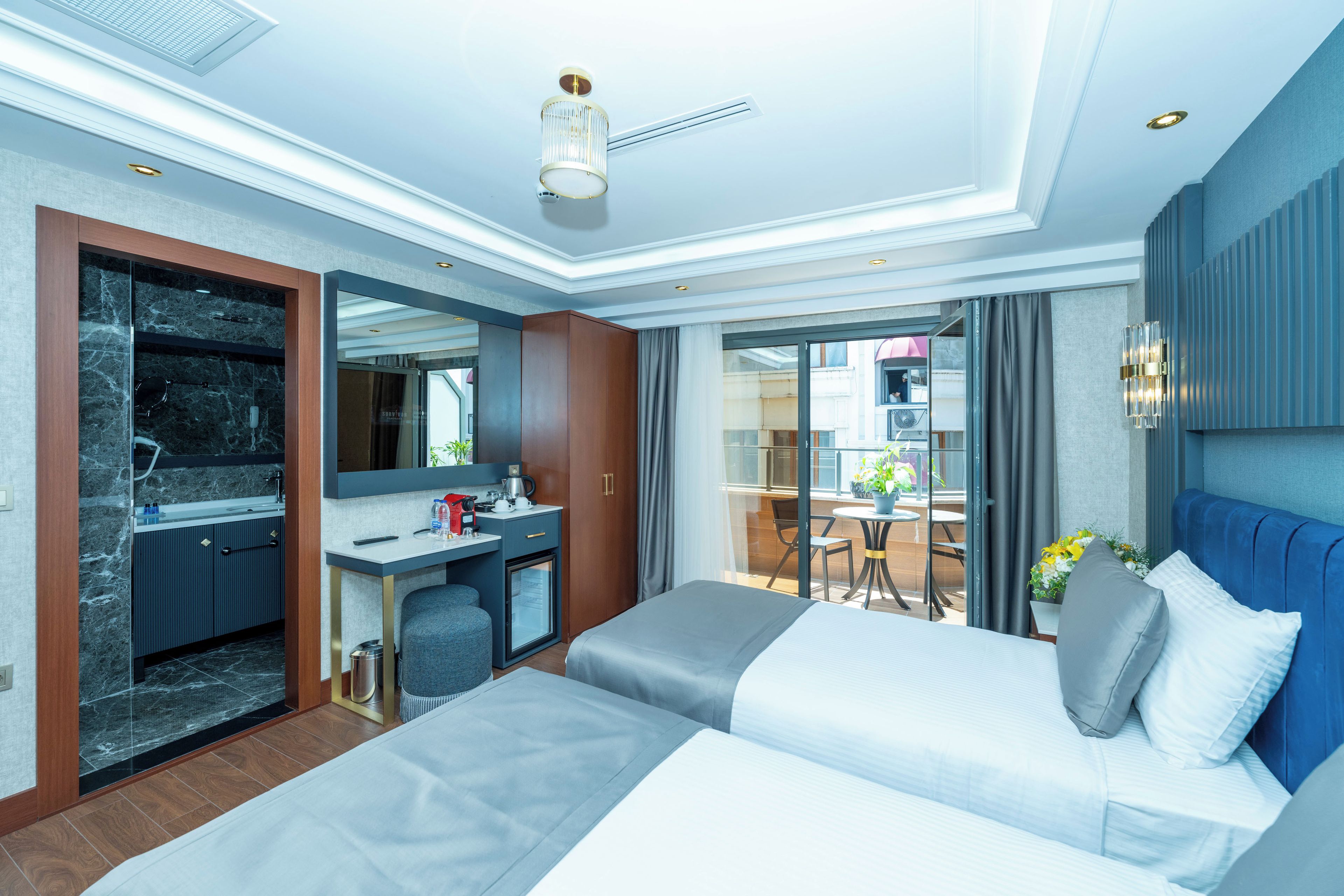 A hotel room with a bed, desk, and a view of the outside.
