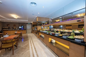 A modern hotel lobby with a buffet area featuring a variety of food options. - Freya Hotel (Istanbul)
