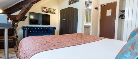 Une chambre à coucher avec un lit, une armoire, un bureau et un téléviseur.