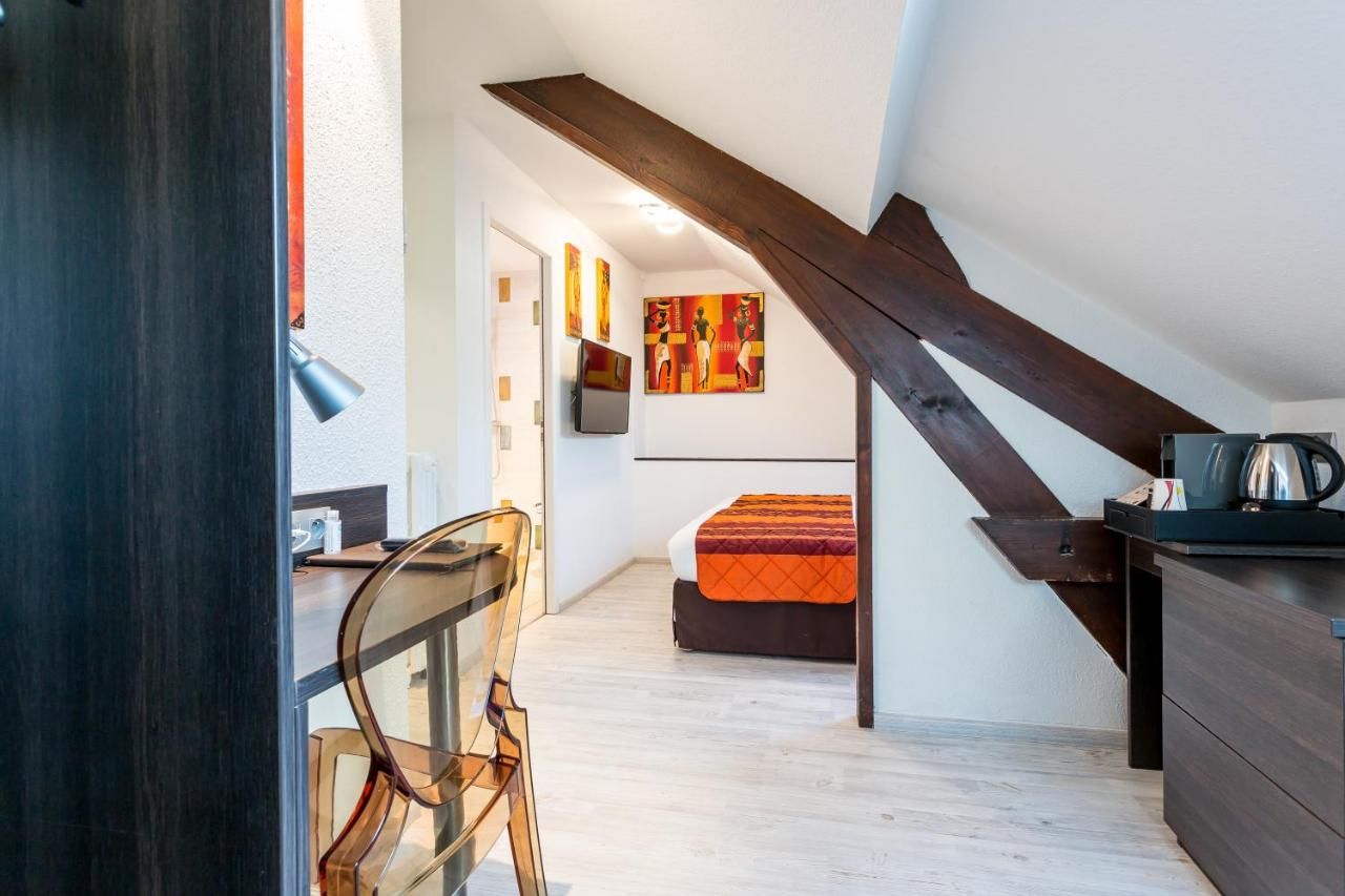 Un dormitorio moderno con techo inclinado, una cama, un escritorio y una silla.