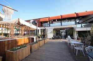 Eine Holzterrasse mit Sitzgelegenheiten und einer Bar, einschließlich Flaschen.