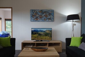 Un saló amb televisió, un quadre i una làmpada.