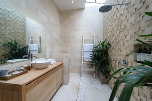 A modern bathroom with a large mirror, a wooden vanity, a shower with a wall-mounted faucet, and a ladder for easy access. - Villa K by Zuzu (Selong Belanak)