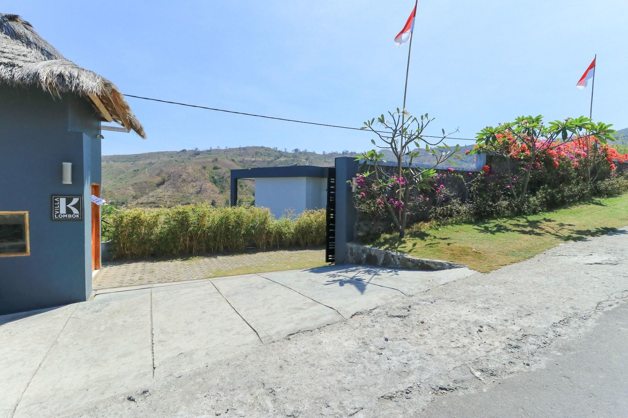 Uma vila com um telhado de palha, um portão e bandeiras.
