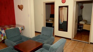 Ein Zimmer mit einem Bett, einem Tisch und zwei Stühlen.