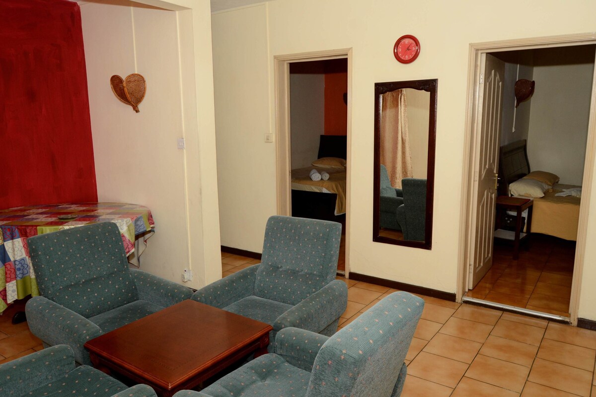 Quarto com uma cama, uma mesa e duas cadeiras.