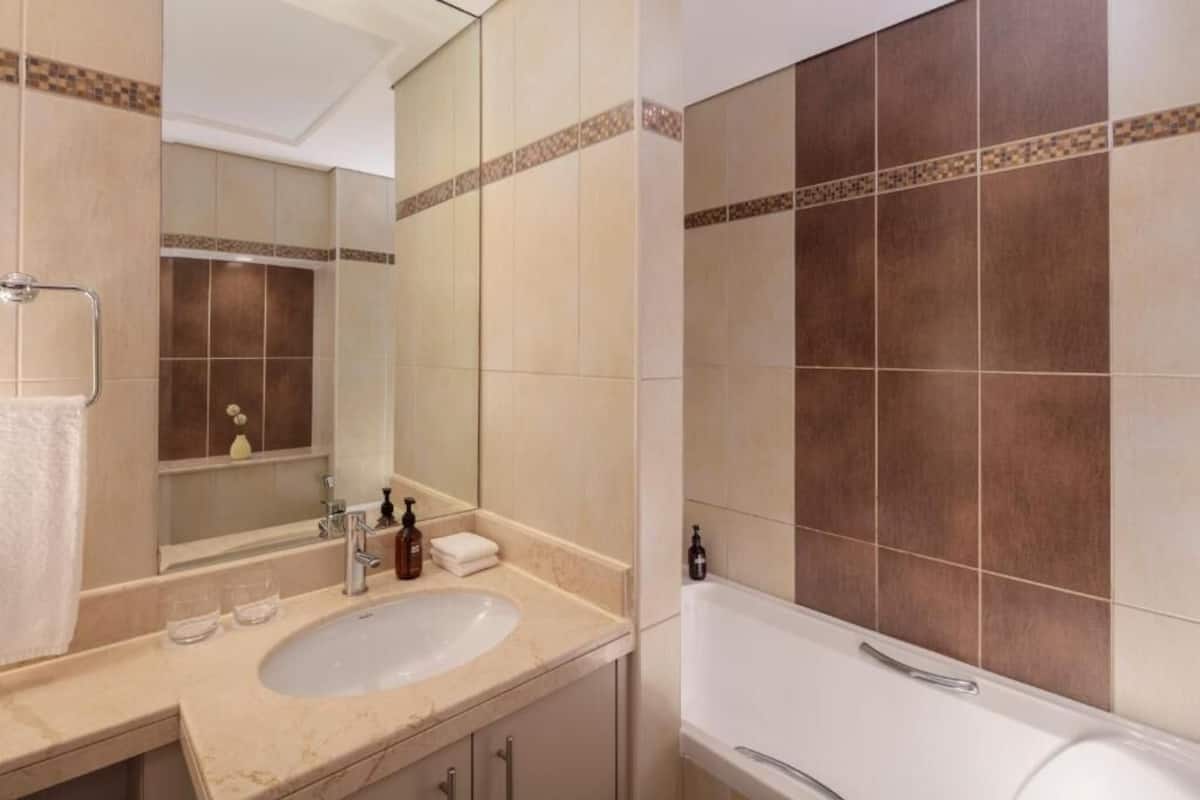 Ein Badezimmer mit Waschbecken, Spiegel und Badewanne.