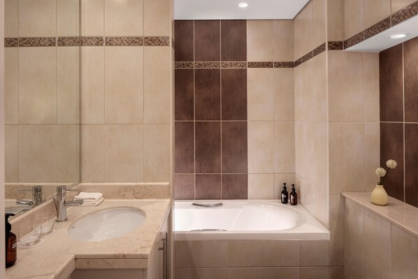 Un baño moderno con lavamanos doble, bañera y un espejo grande.