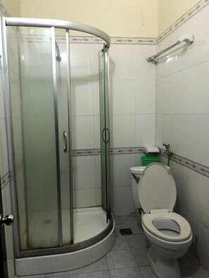 Ein Badezimmer mit einer Duschkabine, einer Toilette und einem Waschbecken.